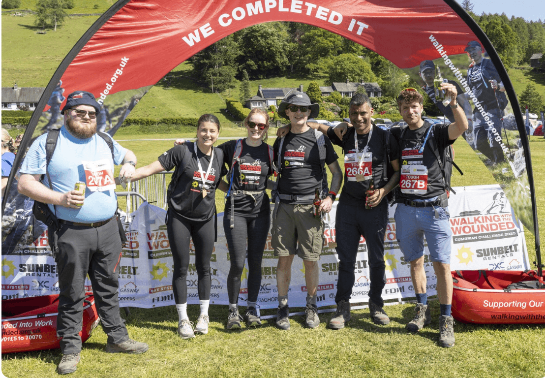 Group of people smiling on the top of a hill