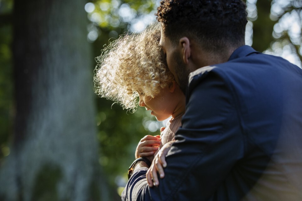 Father holding their child in the forest