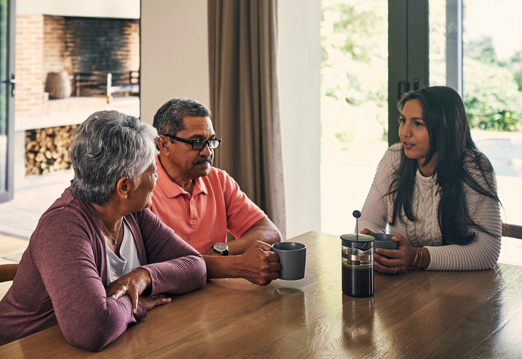 Man and women speaking to a younger female at the dining room table