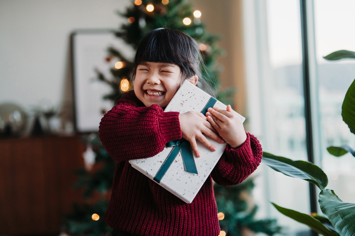 Child holding onto a present smiling