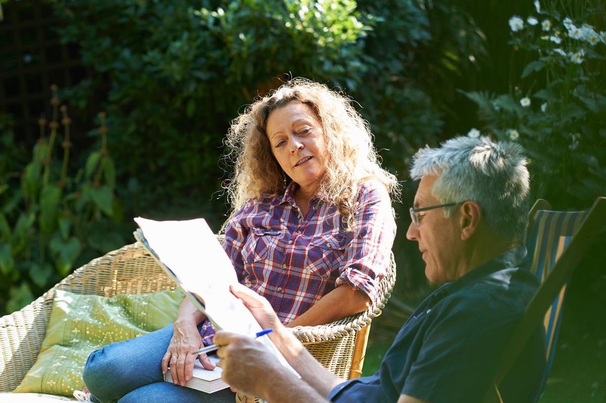 Couple looking through documents in the garden