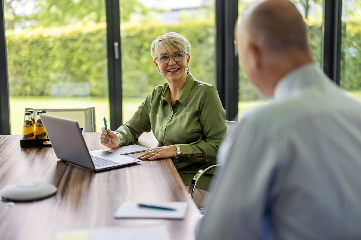 Women chatting with male at the table looking at documents