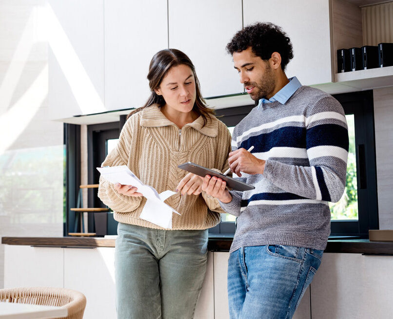 Man and women making notes on a tablet in their kitchen