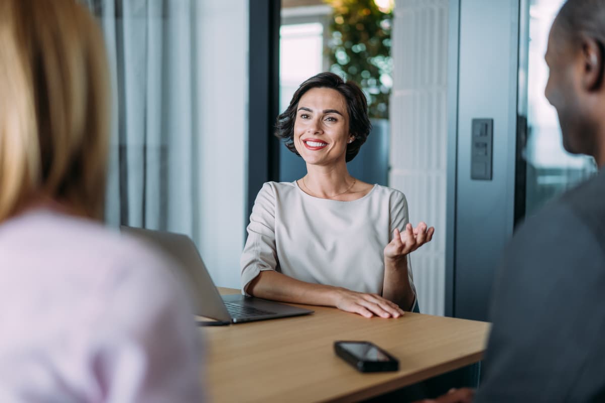 Adviser smiling as she speaks to clients