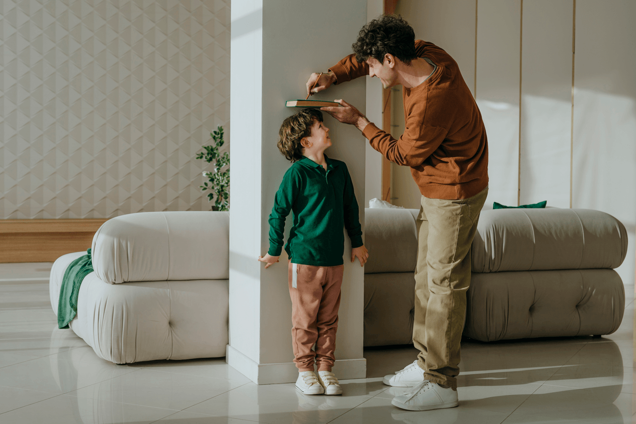 Dad measuring sons height against a wall