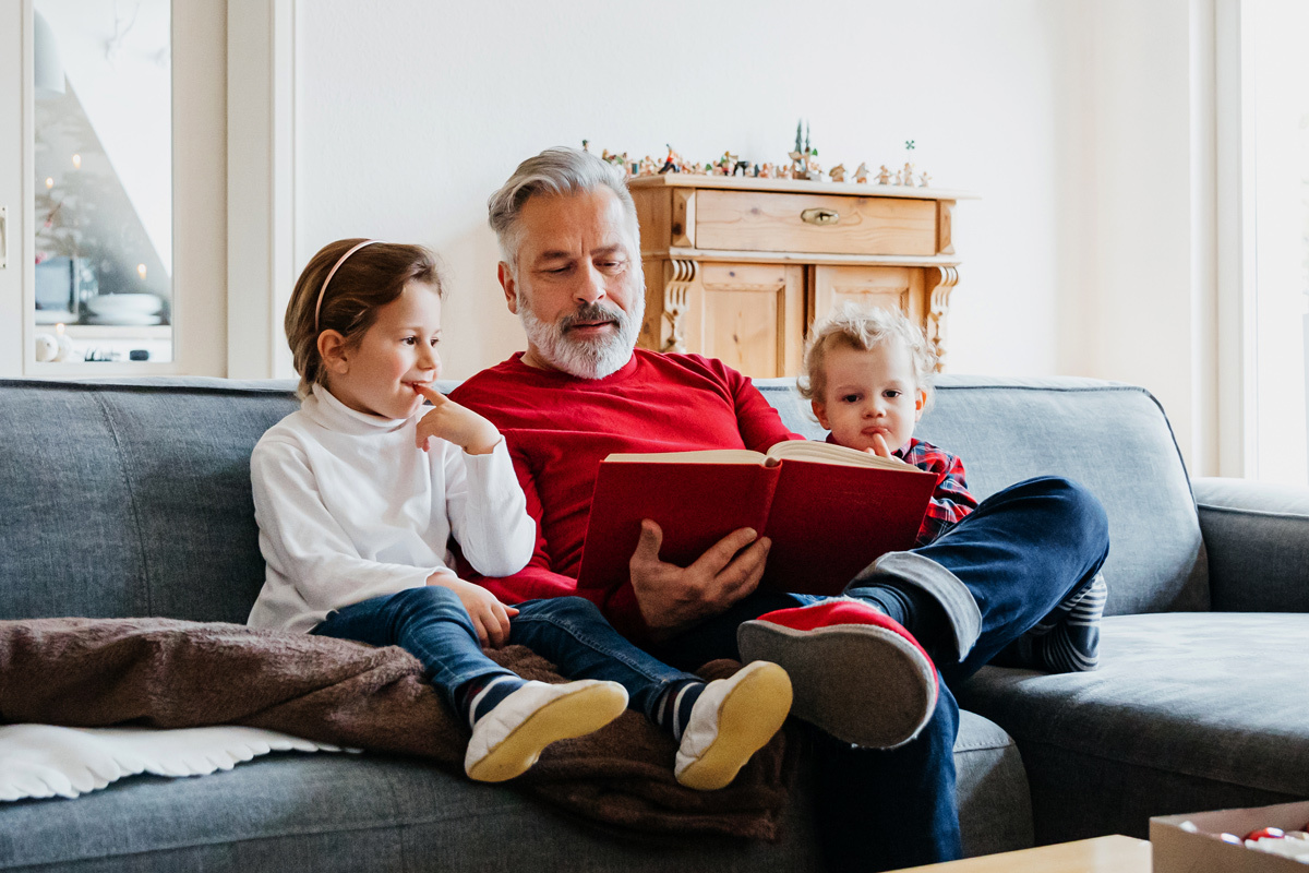 Father reading a book to his children
