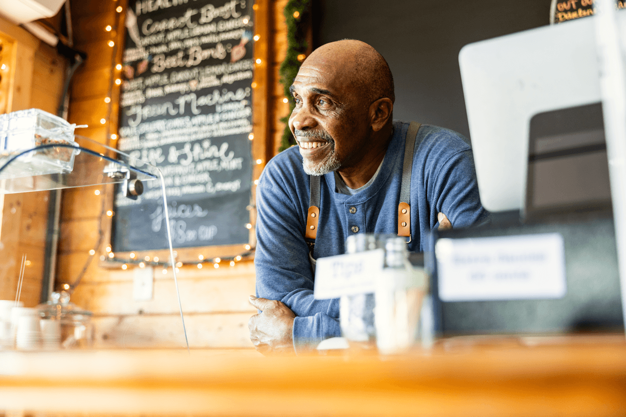 Man leaning on the counter working at a cafe