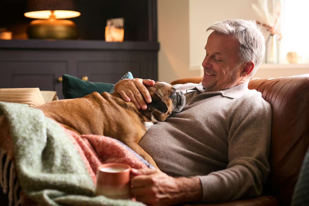 Man sitting on the sofa with his dog