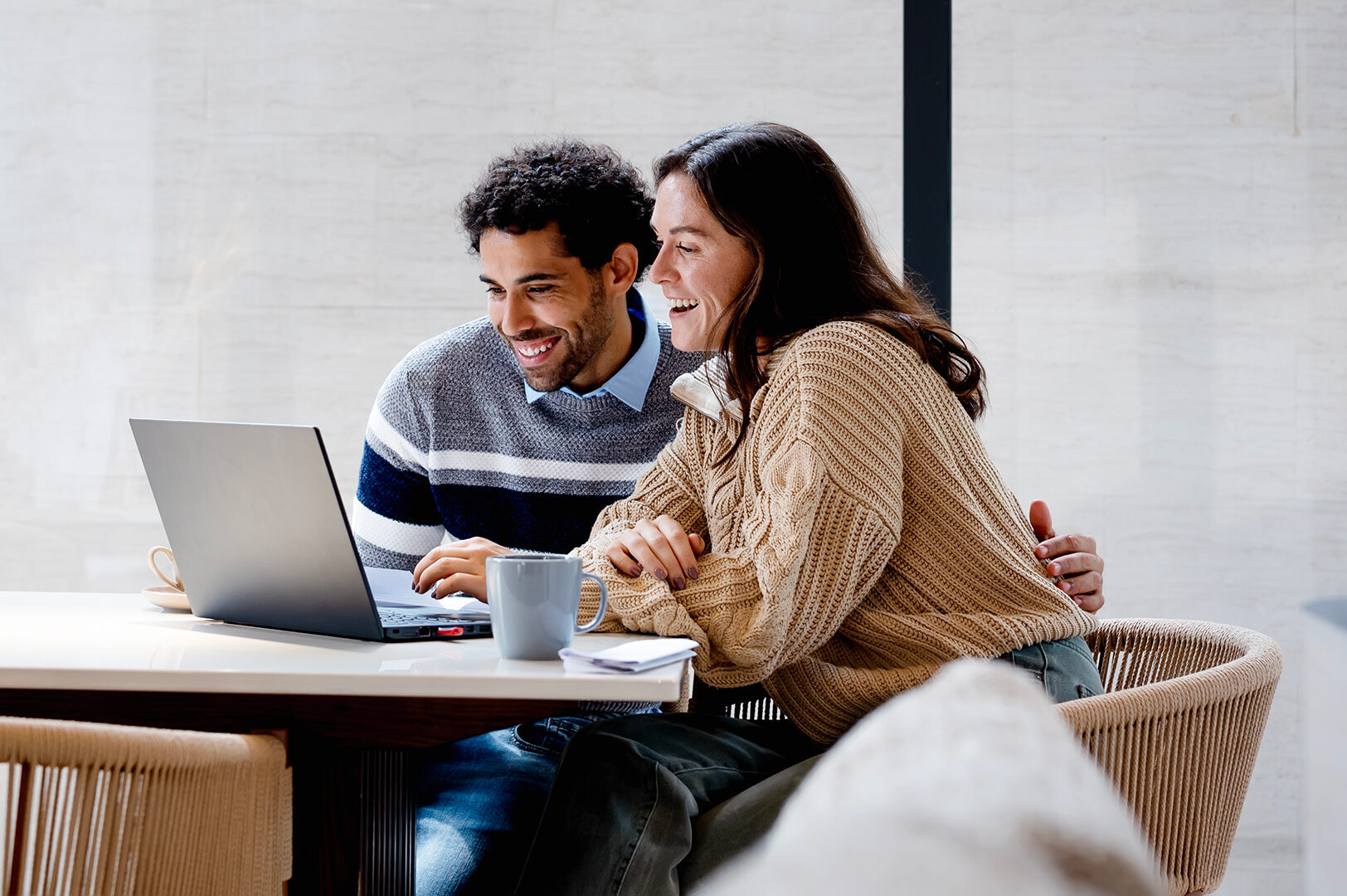 Young man and women sitting looking at their laptop
