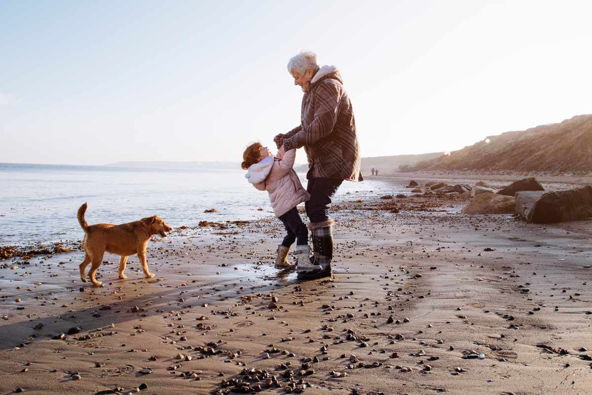 Grandmother and granddaughter playing on the beach