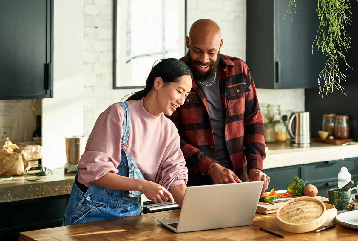 Man and women preparing food in the kitchen smiling