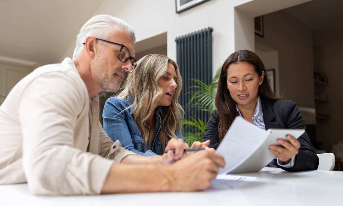 Man and women sitting down with their adviser reviewing documents