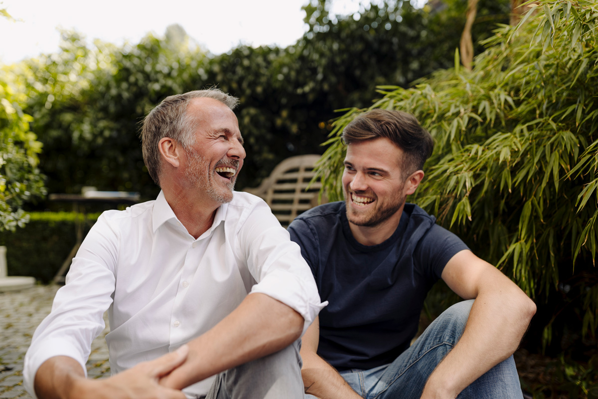 Two men sitting in the garden laughing