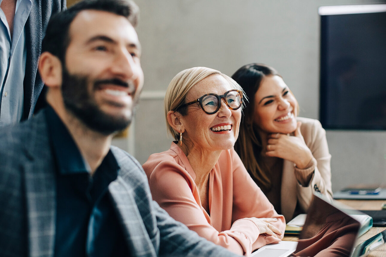 Two women and a man laughing