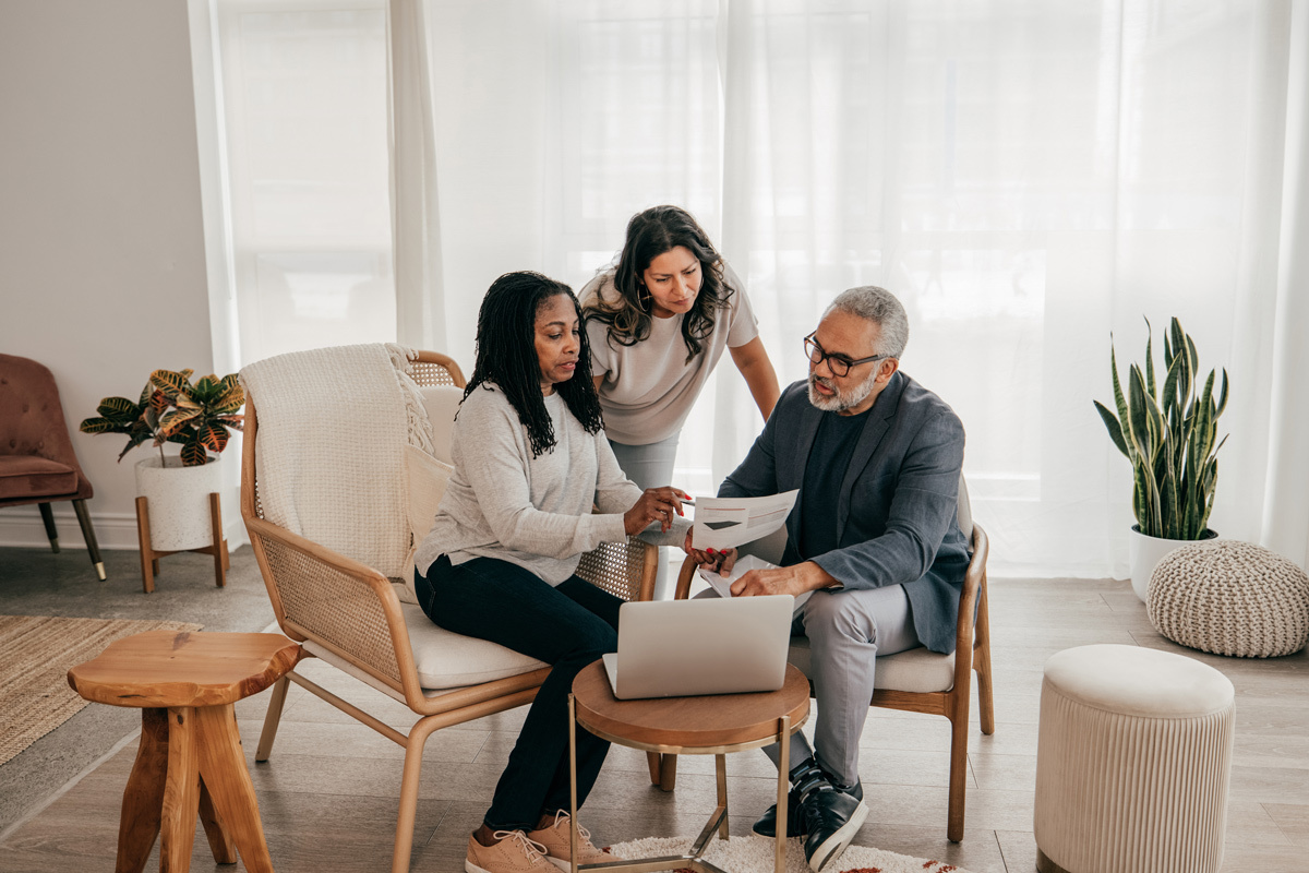 Two women and one man looking at documents