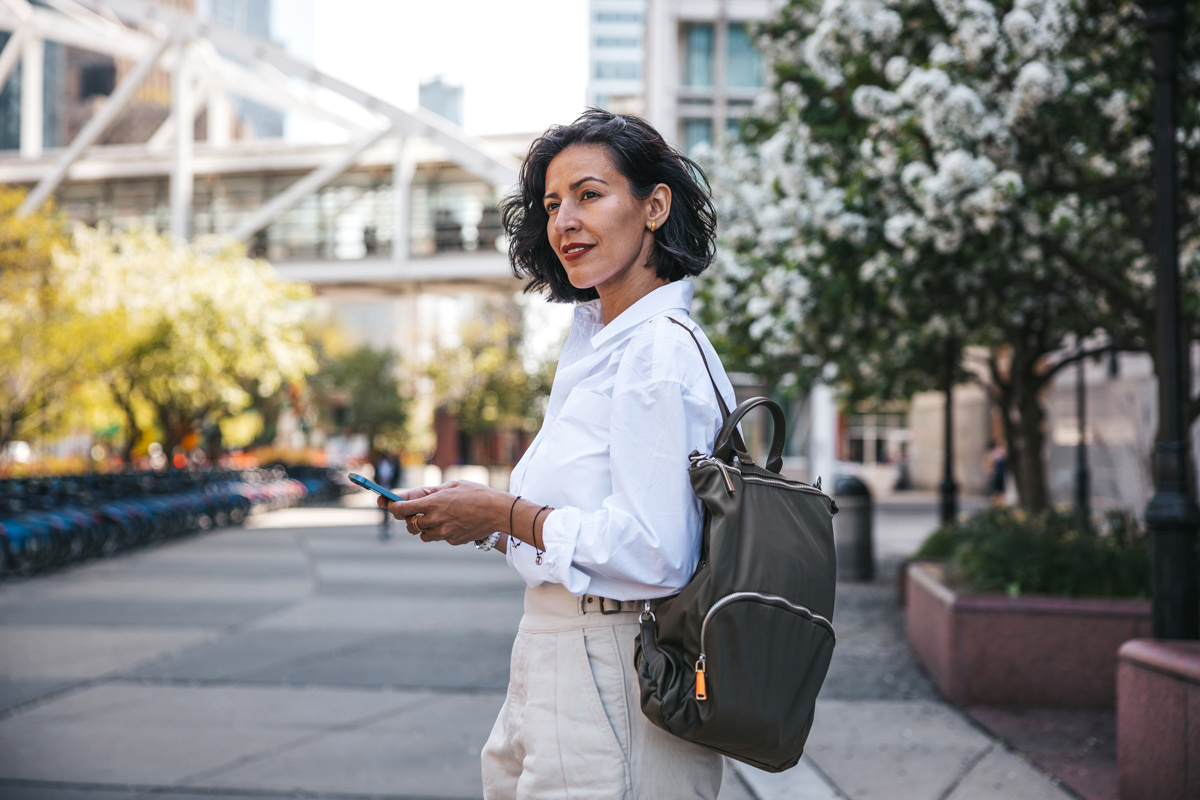 Women walking in the street holding her phone