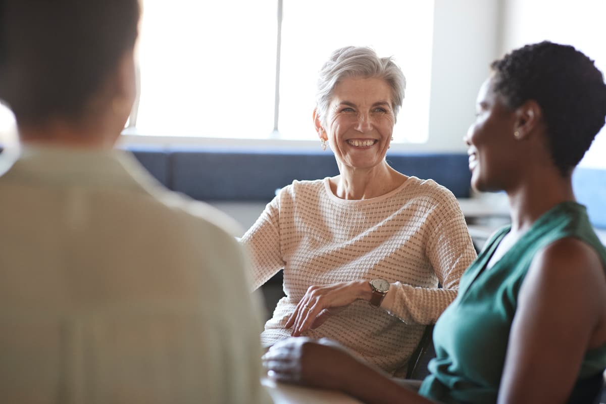 Happy female colleagues discussing in cafeteria