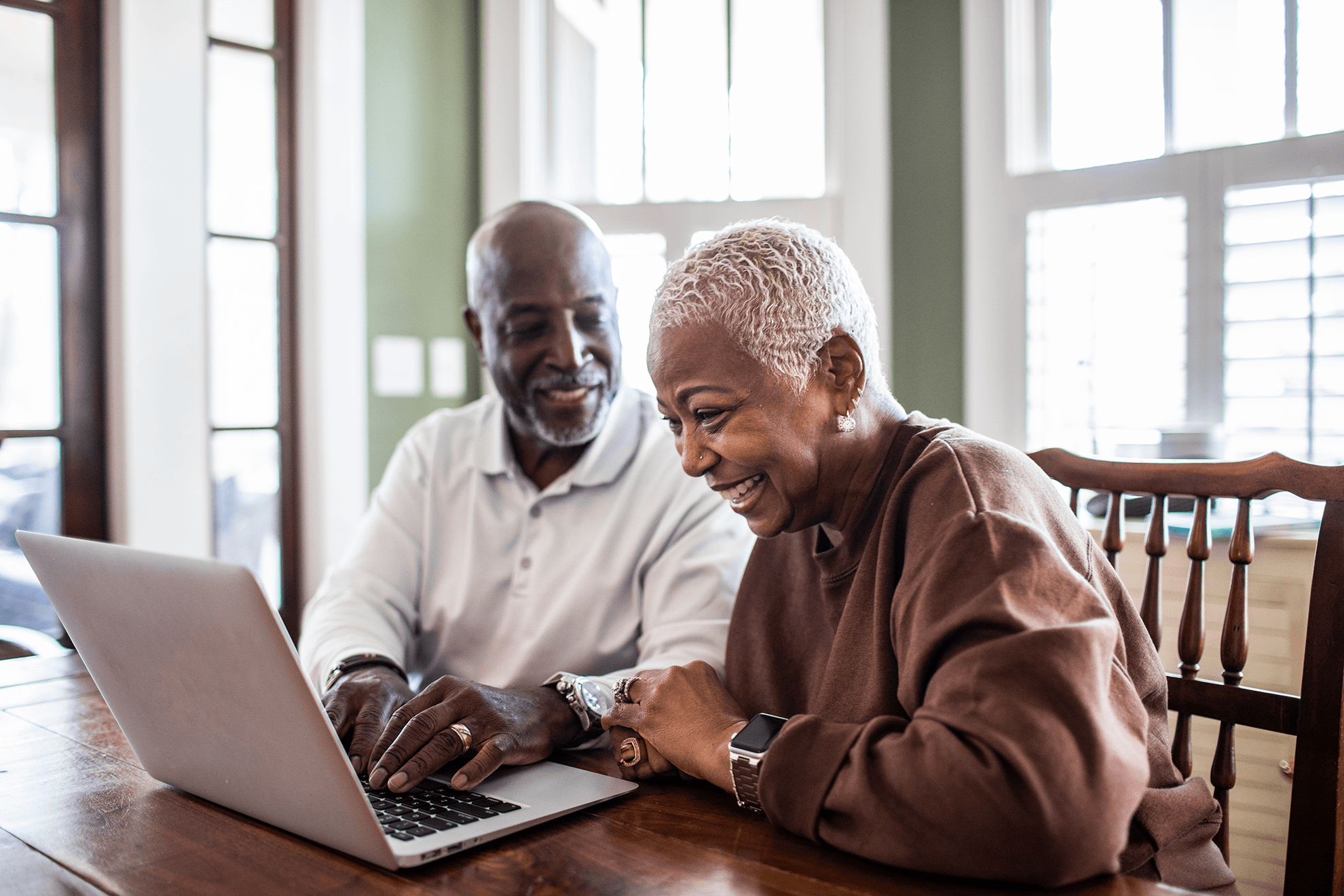 Man and women looking at a laptop smiling